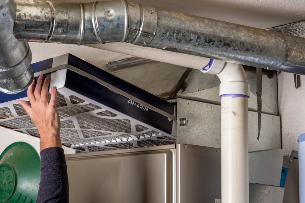 Handyman replaces furnace filter